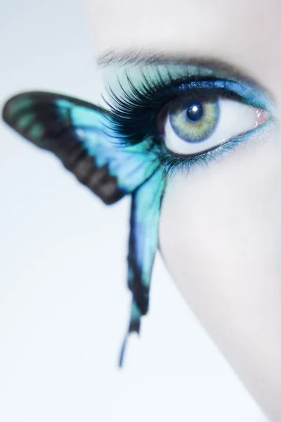 Beautiful woman eye close up with butterfly wings — Stock Photo, Image