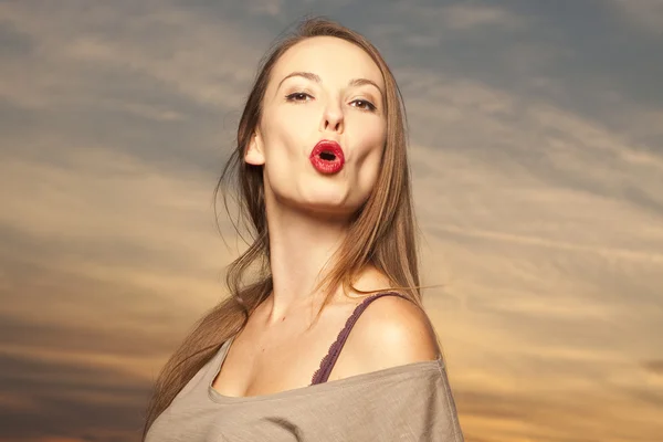 Beautiful and happy woman in front of sunrise background — Stock Photo, Image