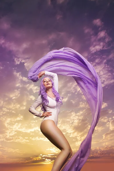 Beautiful woman in front of cloud background with purple chiffon — Stock Photo, Image