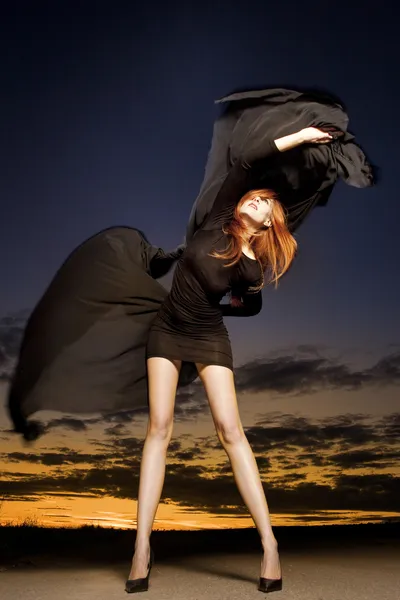 Vacker kvinna stående med glänsande rött hår — Stockfoto