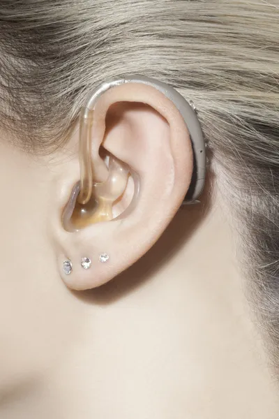 Mooie vrouw oor met gehoorapparaat — Stockfoto