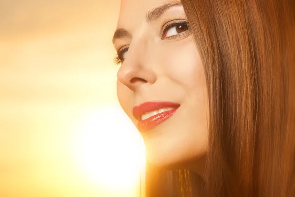 Schöne, glückliche junge Frau im Sonnenlicht — Stockfoto