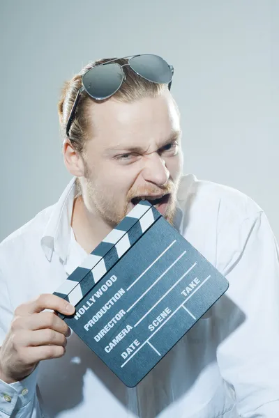 Young man with movie clapper