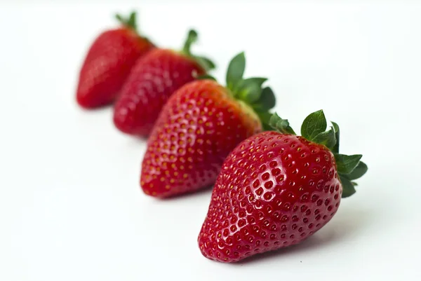 Four strawberries in a row — Stock Photo, Image