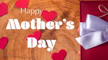 Anneler Günü hakkında bir video, tahta arka planda bir hediye ve kalplerle.