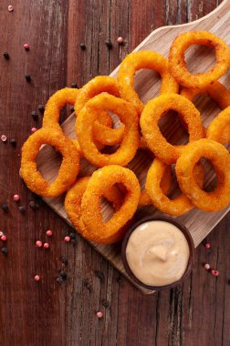 Baharatlı soslu ev yapımı lezzetli kızarmış soğan halkaları. Üst Manzara. Boşluğu kopyala