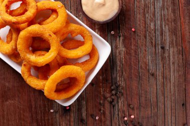 Baharatlı soslu ev yapımı lezzetli kızarmış soğan halkaları. Üst Manzara. Boşluğu kopyala