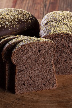 Tahtanın üzerinde koyu renkli un bulunan ev yapımı Avustralya ekmeği.