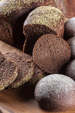 Tahtanın üzerinde koyu renkli un bulunan ev yapımı Avustralya ekmeği.