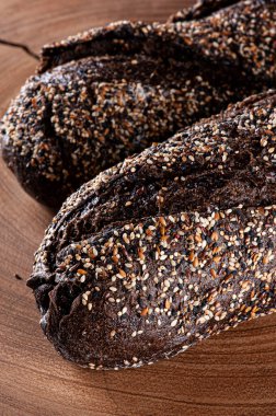 Tahtanın üzerinde koyu renkli un bulunan ev yapımı Avustralya ekmeği.