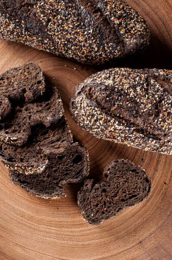 Tahtanın üzerinde koyu renkli un bulunan ev yapımı Avustralya ekmeği.