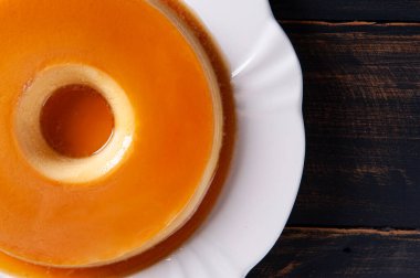 Beyaz tabakta lezzetli yoğunlaştırılmış sütlü puding. Üst Manzara. Boşluğu kopyala.