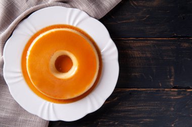 Beyaz tabakta lezzetli yoğunlaştırılmış sütlü puding. Üst Manzara. Boşluğu kopyala.