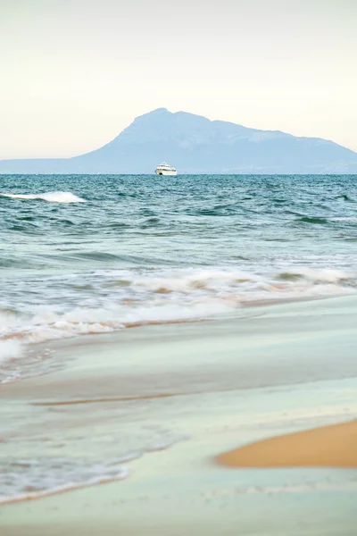 Tourist boat with mountains in the background — Stock Photo, Image