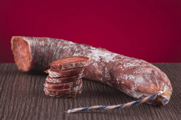 Chorizo Iberico bir tablo üzerinde kırmızı bir arka plan