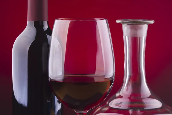 Szkło i butelkę wina na czerwonym tle — Zdjęcie stockowe