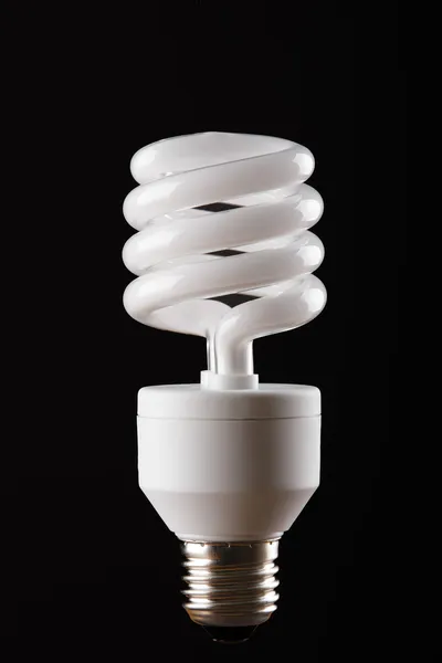Energy saving lamp on black background — Stock Photo, Image