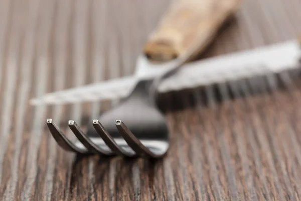 Gabel und Messer auf einem Holzbrett. verschwommener Hintergrund. — Stockfoto