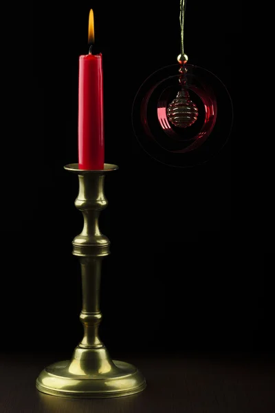 Lighted candle next to a Christmas detail — Stock Photo, Image