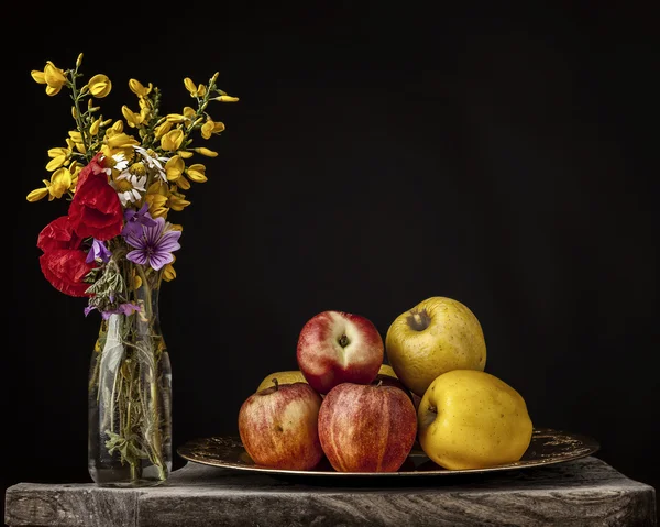 Nature morte avec des fleurs et des pommes sur une planche en bois — Photo