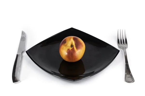 Nectarine on a plate next to a cutlery — Stock Photo, Image