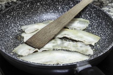 bir tavada domuz pastırması şeritler