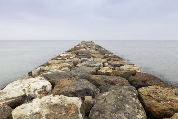 Rochers de digue dans la mer Photo De Stock