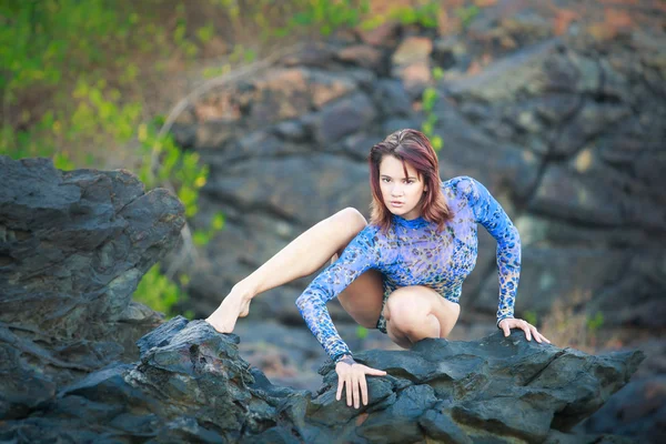 体操の女の子が石の上に座っています。 — ストック写真