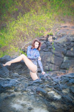 bir taş üzerinde oturan jimnastikçi kız