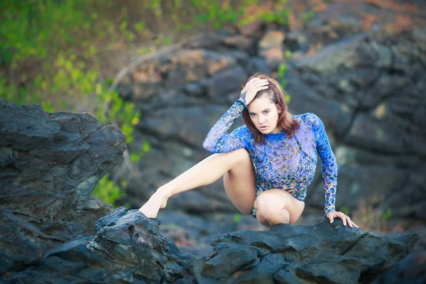 Gymnast girl sitting on a stone — Stock Photo, Image