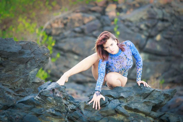 bir taş üzerinde oturan jimnastikçi kız