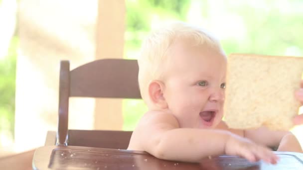 Baby taking and eating bread — Stock Video