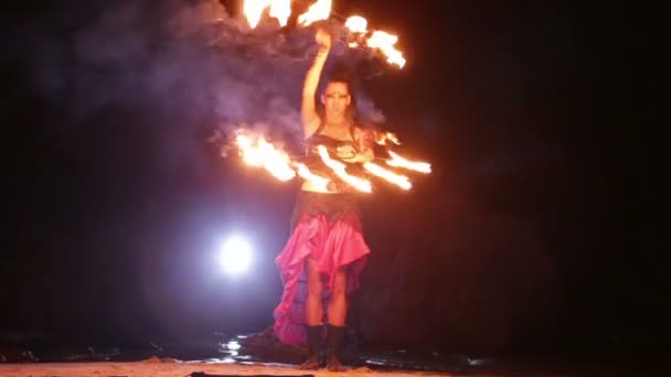 Artista gira los ventiladores de fuego en torno a sí mismo — Vídeo de stock