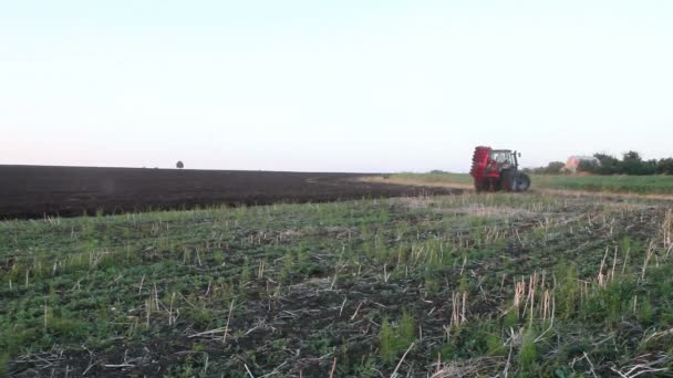 Traktor pflügt Feld bei Sonnenuntergang — Stockvideo