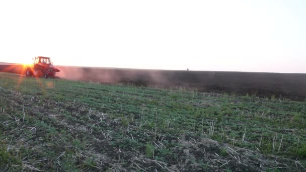 Campo de arado de trator ao pôr-do-sol — Vídeo de Stock