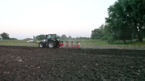 Traktor pflügt Feld bei Sonnenuntergang — Stockvideo
