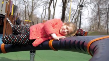 Şaşkın sarışın çocuk siyah turuncu cazibede yatıyor.