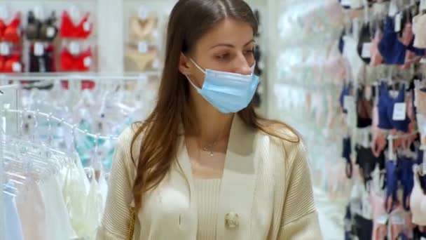 Vrouw met masker in lingerie afdeling van fashion store — Stockvideo