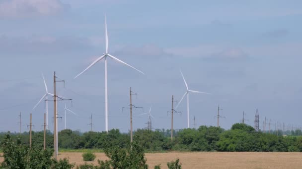 Turbiny elektrowni wiatrowych działają w pobliżu linii energetycznych — Wideo stockowe