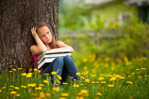 Chica de la escuela cansada en el parque con libros —  Fotos de Stock