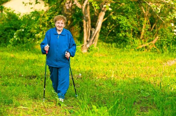 Vecchia attiva (85 anni) nordic walking all'aperto . — Foto Stock