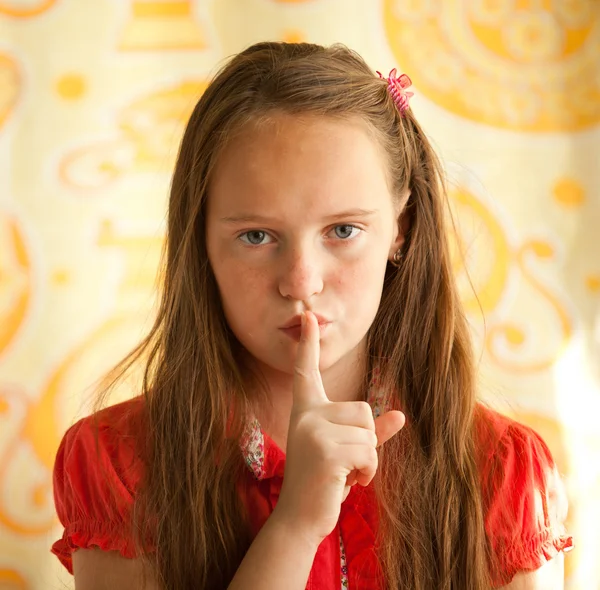 Junges Mädchen mit dem Finger über dem Mund. — Stockfoto