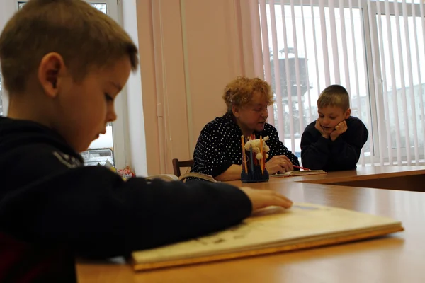 El día de puertas abiertas en Podporozhye 's Children House - los niños desconocidos en la biblioteca leen los libros con los maestros —  Fotos de Stock