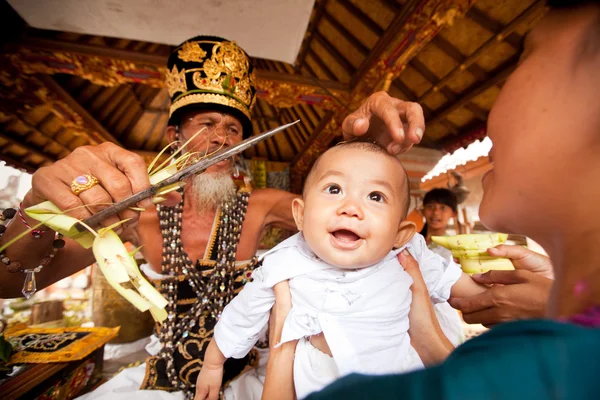 BALI, INDONESIA - MARCH 28: Unidentified child during the ceremonies of Oton - is the first ceremony for baby's on which the infant is allowed to touch the ground on March 28, 2012 on Bali, Indon — Stock Photo, Image