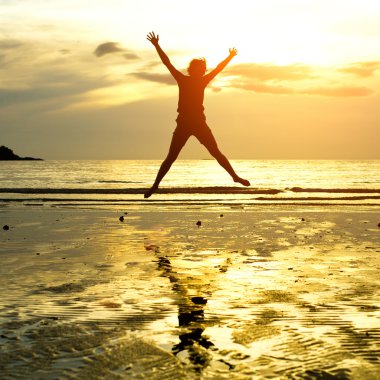 genç kız, karşı deniz günbatımı atlama silüeti