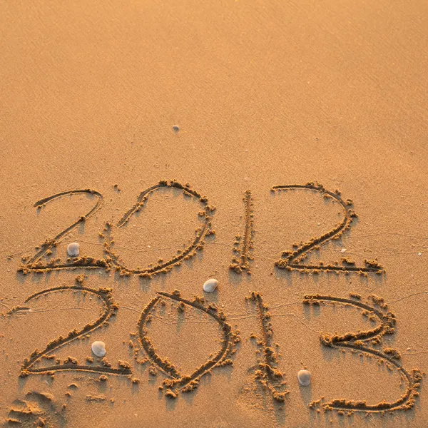 Inscriptie 2012 en 2013 op een strand — Stockfoto