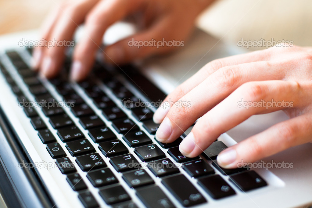 Hands typing on the laptop keyboard