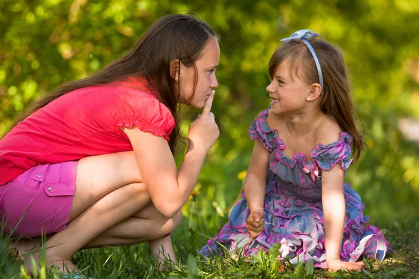 Belle jeune fille avec son doigt sur la bouche montre pour enfant espiègle - Chut. secret . — Photo