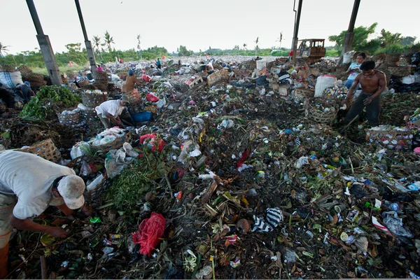 Bali, Indonesië worden-april 11: armen van java eiland werken in een opruiming op de stortplaats op 11 april 2012 op bali, Indonesië. Bali geproduceerd dagelijks 10.000 kubieke meter van afval. — Stockfoto