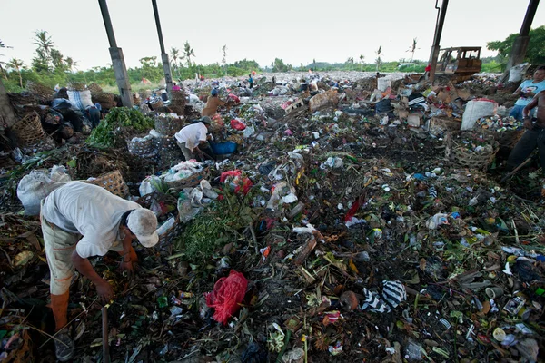 Bali, Indonesië worden-april 11: armen van java eiland werken in een opruiming op de stortplaats op 11 april 2012 op bali, Indonesië. Bali geproduceerd dagelijks 10.000 kubieke meter van afval. — Stockfoto